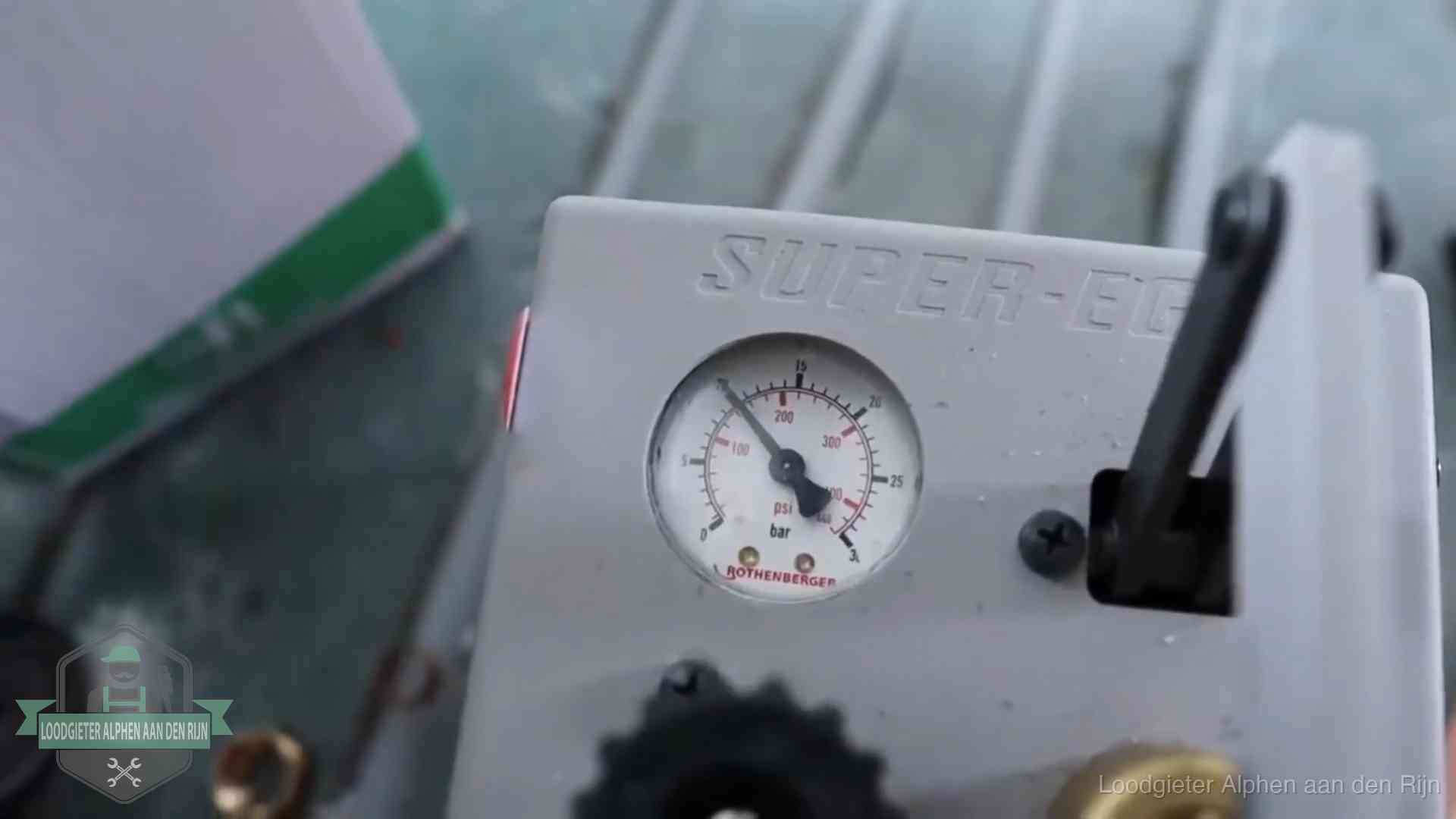 Manometer van een afperspomp bij controle van nieuw leidingwerk in Alphen aan den Rijn