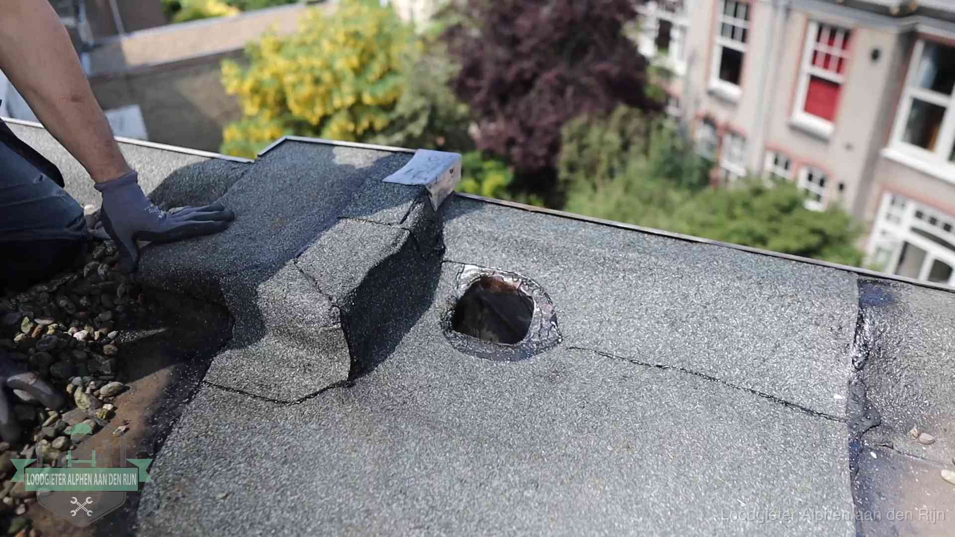 Daklekkage-inspectie op een plat dak in Alphen aan den Rijn Loodgieter inspecteert een beschadigd bitumen plat dak tijdens een daklekkage-inspectie in Alphen aan den Rijn