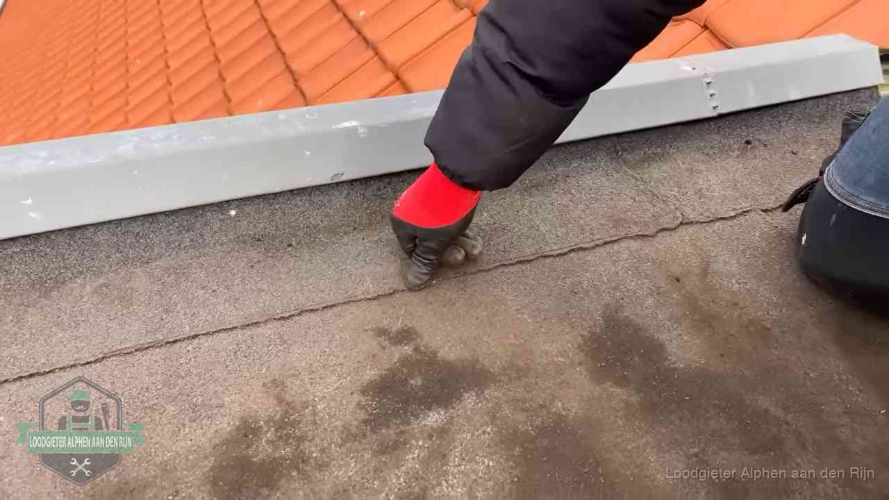 Lekkage bij de naad van een plat dak in Alphen aan den Rijn Vakman wijst een naad met vochtplekken aan op een bitumen plat dak in Alphen aan den Rijn