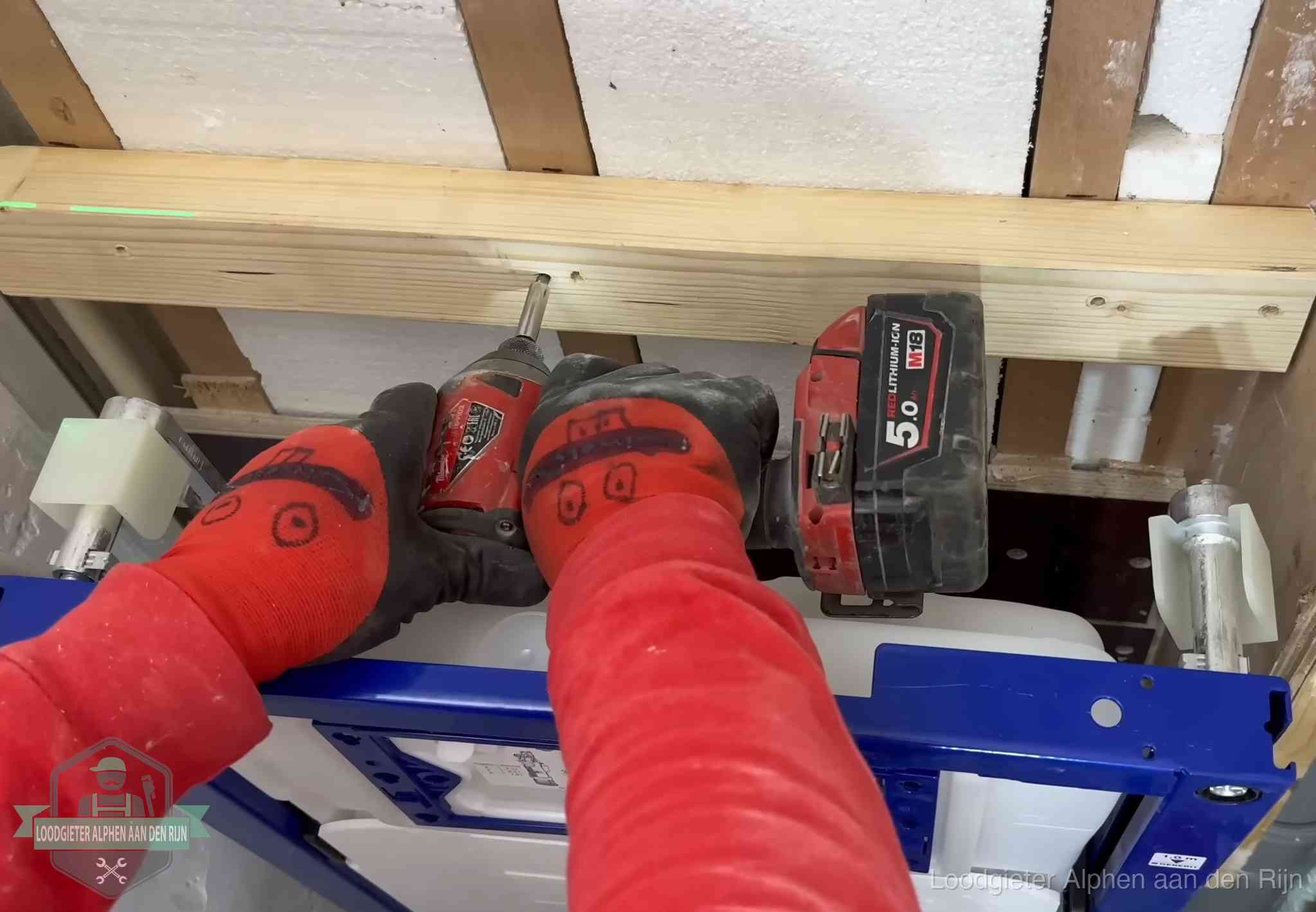 Monteur bevestigt een inbouwreservoir voor een hangend toilet in Alphen aan den Rijn