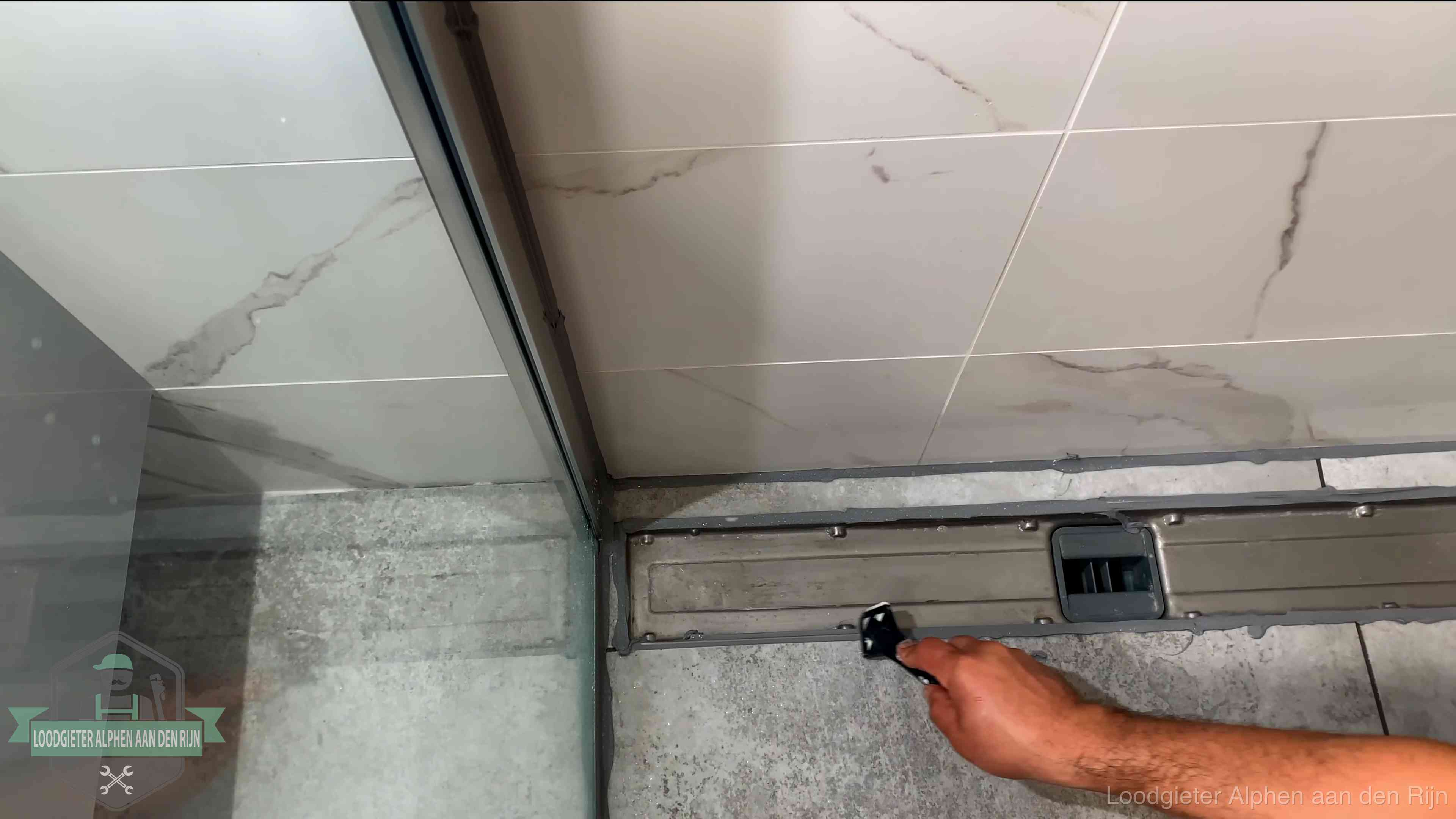 Lekkage in de badkamer verhelpen in Alphen aan den Rijn Verse kitrand langs de douchegoot in een betegelde badkamer in Alphen aan den Rijn