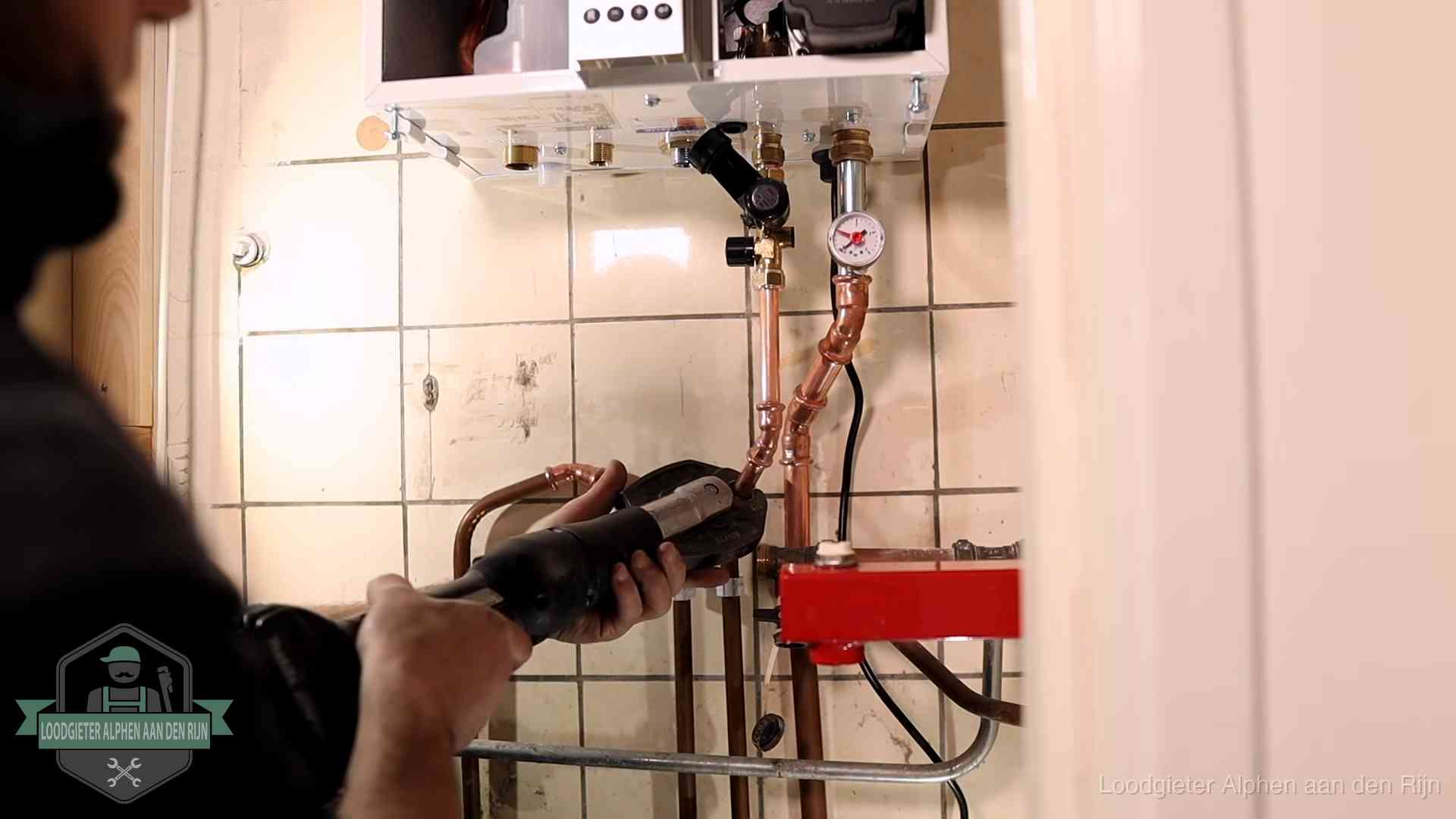 Cv-ketel onderhoud in Alphen aan den Rijn Monteur werkt aan de leidingen onder een cv-ketel in Alphen aan den Rijn