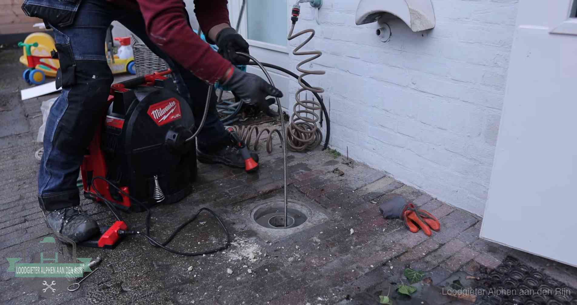 Erfgrens en gemeenteriool in Alphen aan den Rijn Ontstoppingsputje in de bestrating naast de gevel van een woning in Alphen aan den Rijn