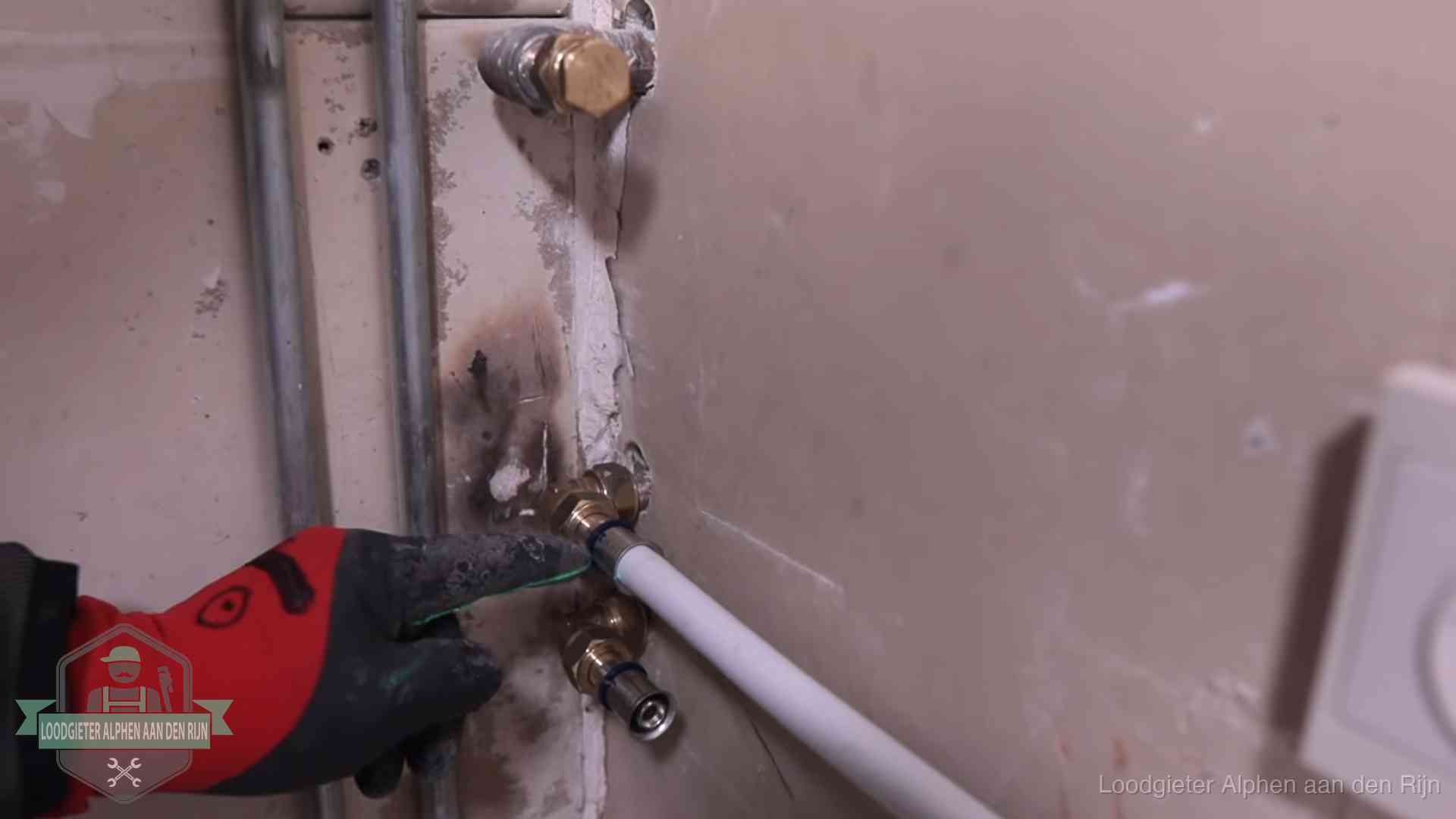 Loodgieter wijst de persfitting op nieuwe muuraansluitingen aan in een woning in Alphen aan den Rijn