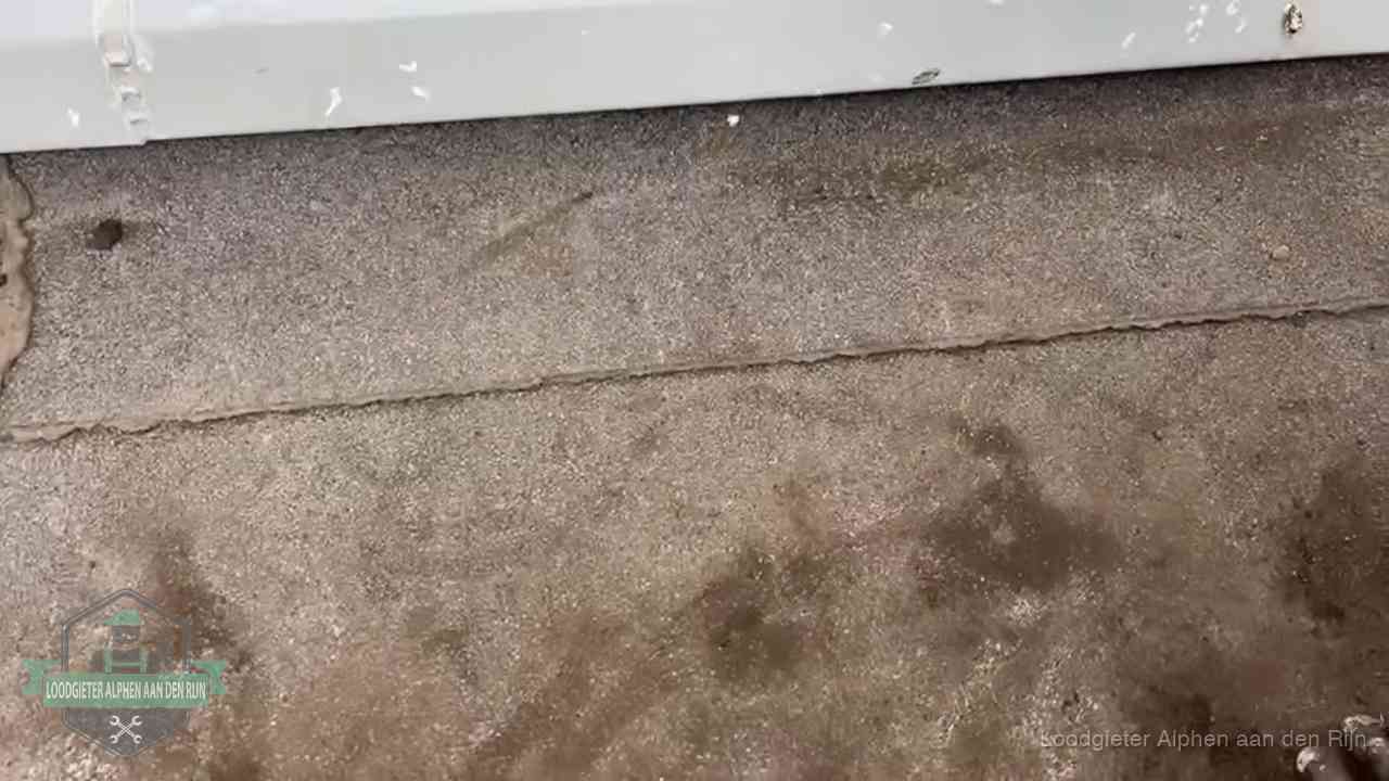 Stormschade en neerslag op daken in Alphen aan den Rijn Vochtplekken bij de naad van een plat dak na aanhoudende regen in Alphen aan den Rijn