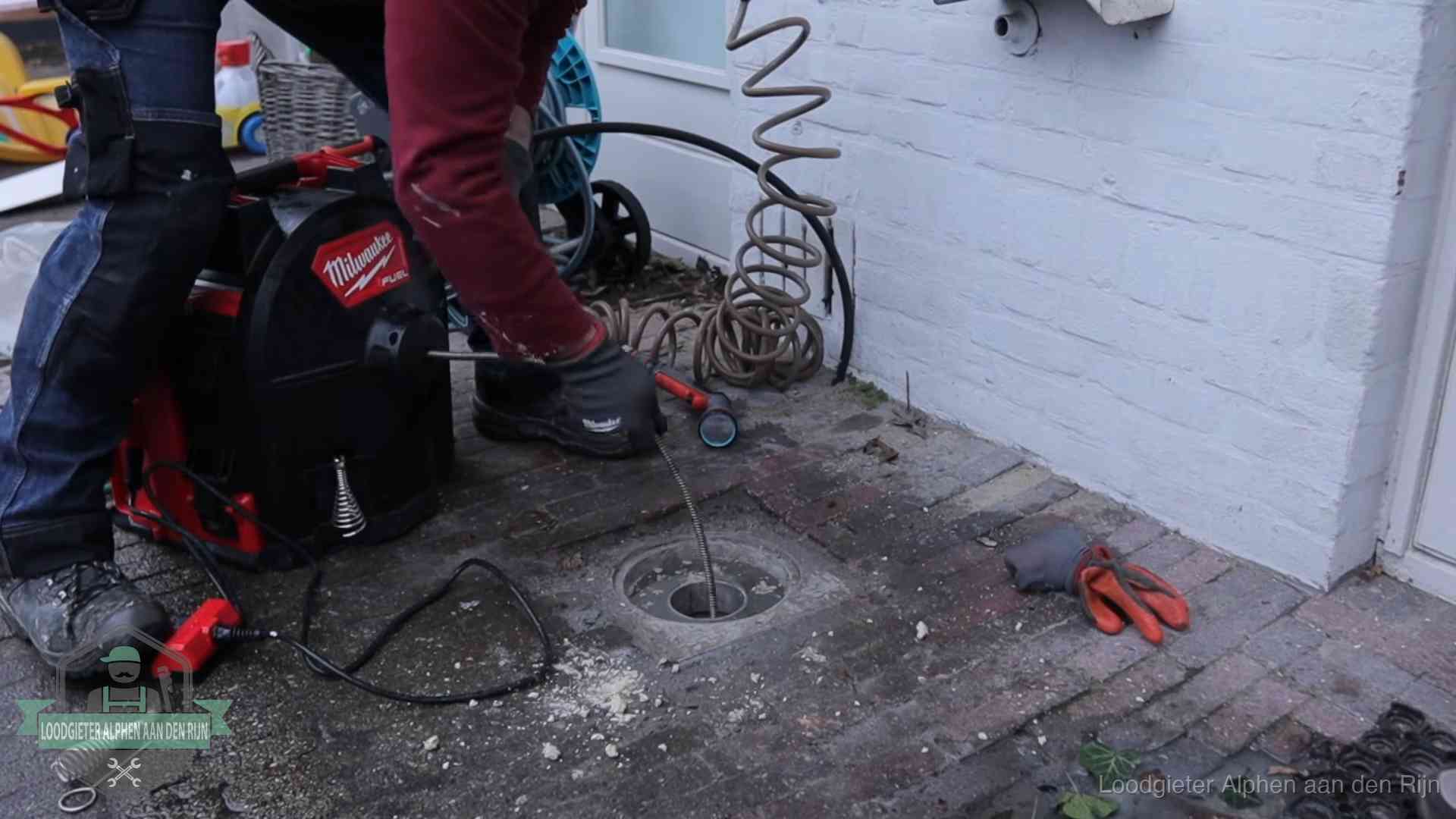 Prijs van een rioolontstopping in Alphen aan den Rijn Spiraalmachine bij een ontstoppingsputje in de bestrating in Alphen aan den Rijn