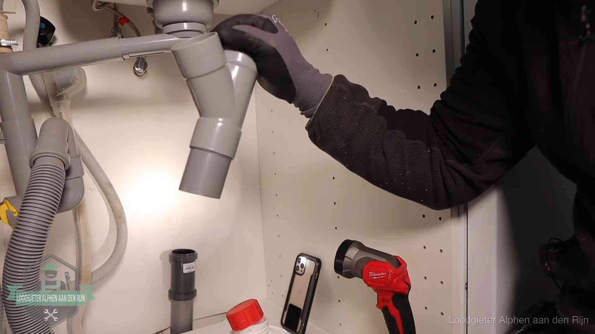 Rioollucht in huis verhelpen in Alphen aan den Rijn Loodgieter demonteert het sifon- en afvoerwerk onder een gootsteen in Alphen aan den Rijn bij stankklachten