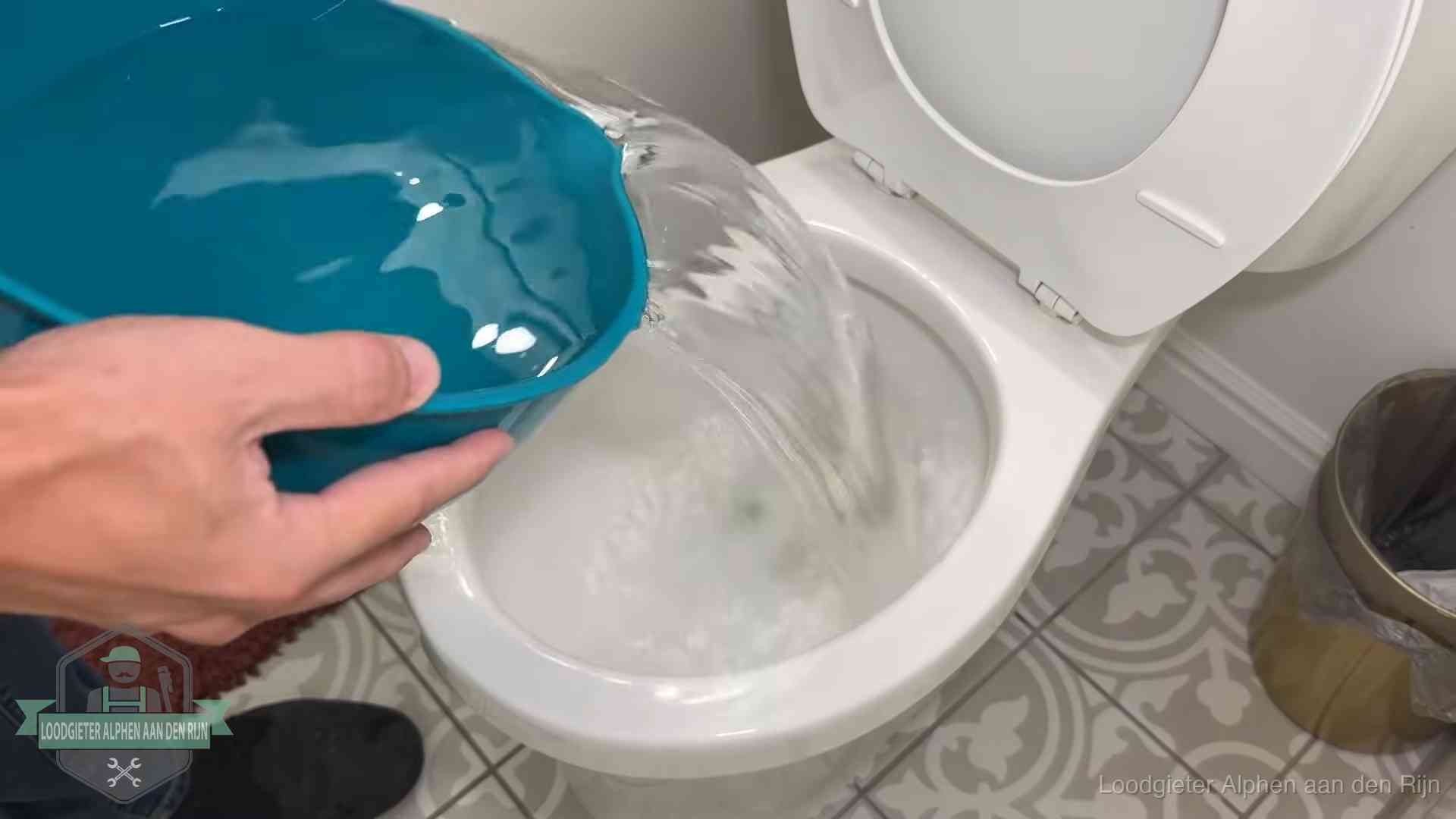 Warm water wordt voorzichtig in de wc-pot gegoten in Alphen aan den Rijn