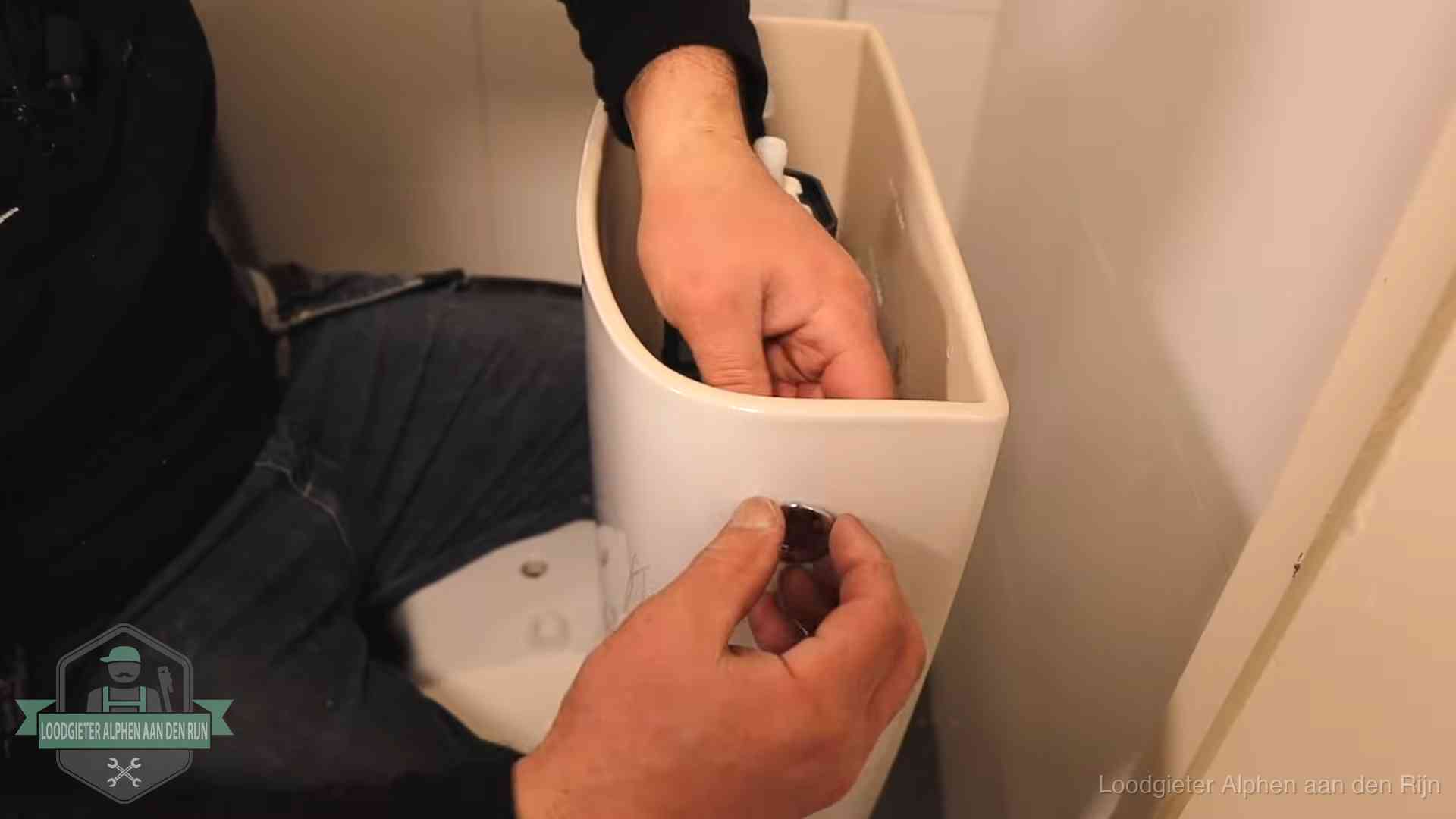 Drukknop van een duoblok-stortbak wordt gemonteerd bij een toilet in Alphen aan den Rijn